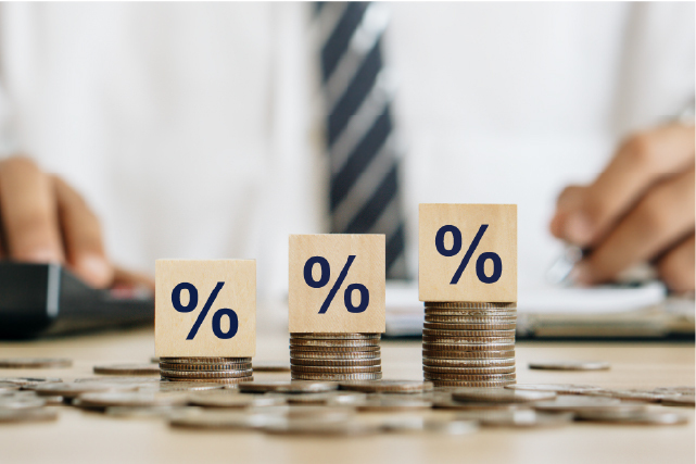 Stacked coins with percentage blocks representing increasing value, ROI, or investment growth in real estate.