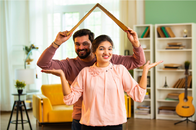 Happy couple symbolizing a new home with a roof gesture, representing smart home buying choices.